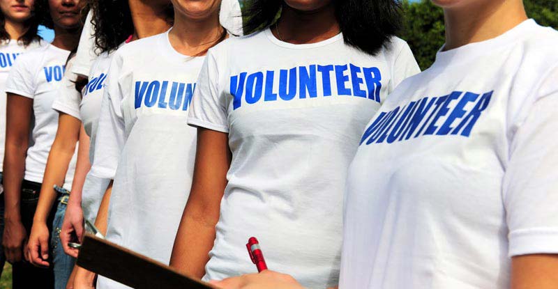 Several people wearing t-shirts that read "Volunteer"